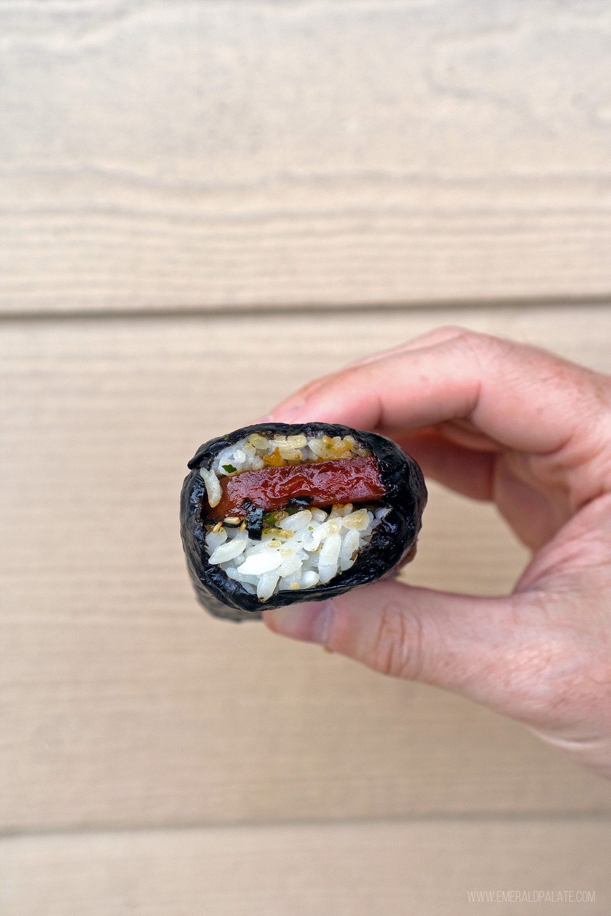 person holding a spam musubi