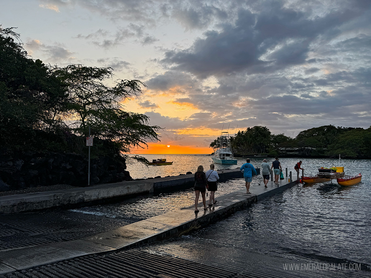 people walking on a dock at sunset to do a manta ray tour, one of the best things to do on the Big Island in Hawaii