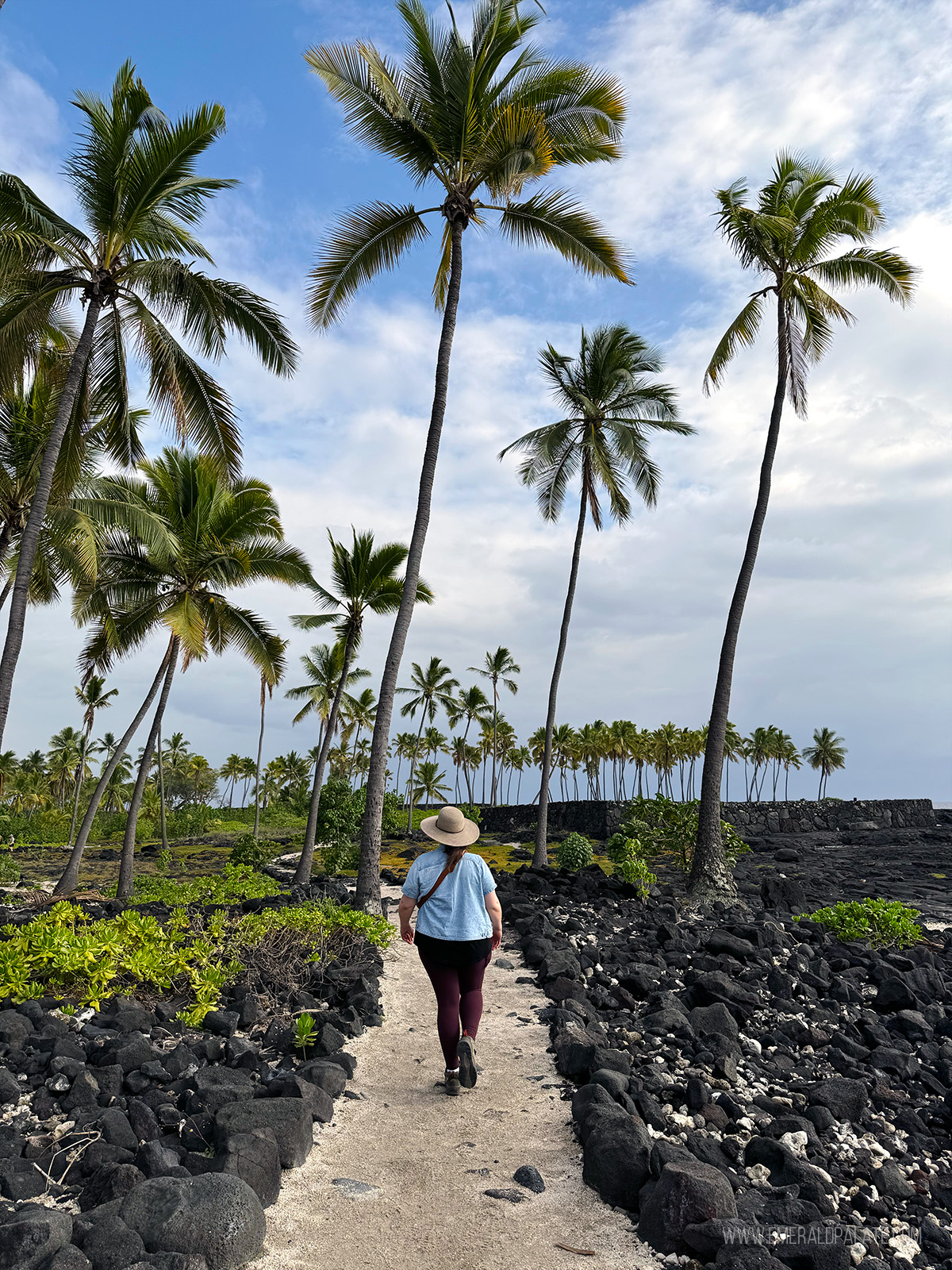 person walking with a historic Hawaiian landmark, one of the best things to do on the Big Island in Hawaii