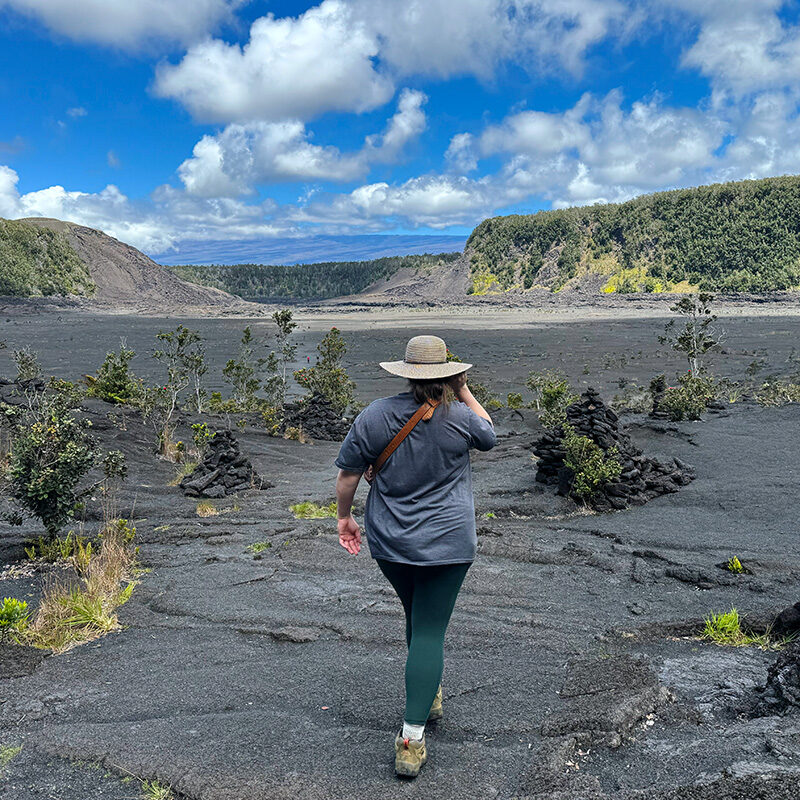woman walking through a crater, one of the best things to do in Volcanoes National Park in Hawaii