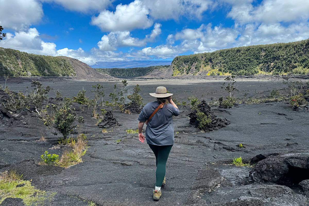 woman walking through a crater, one of the best things to do in Volcanoes National Park in Hawaii