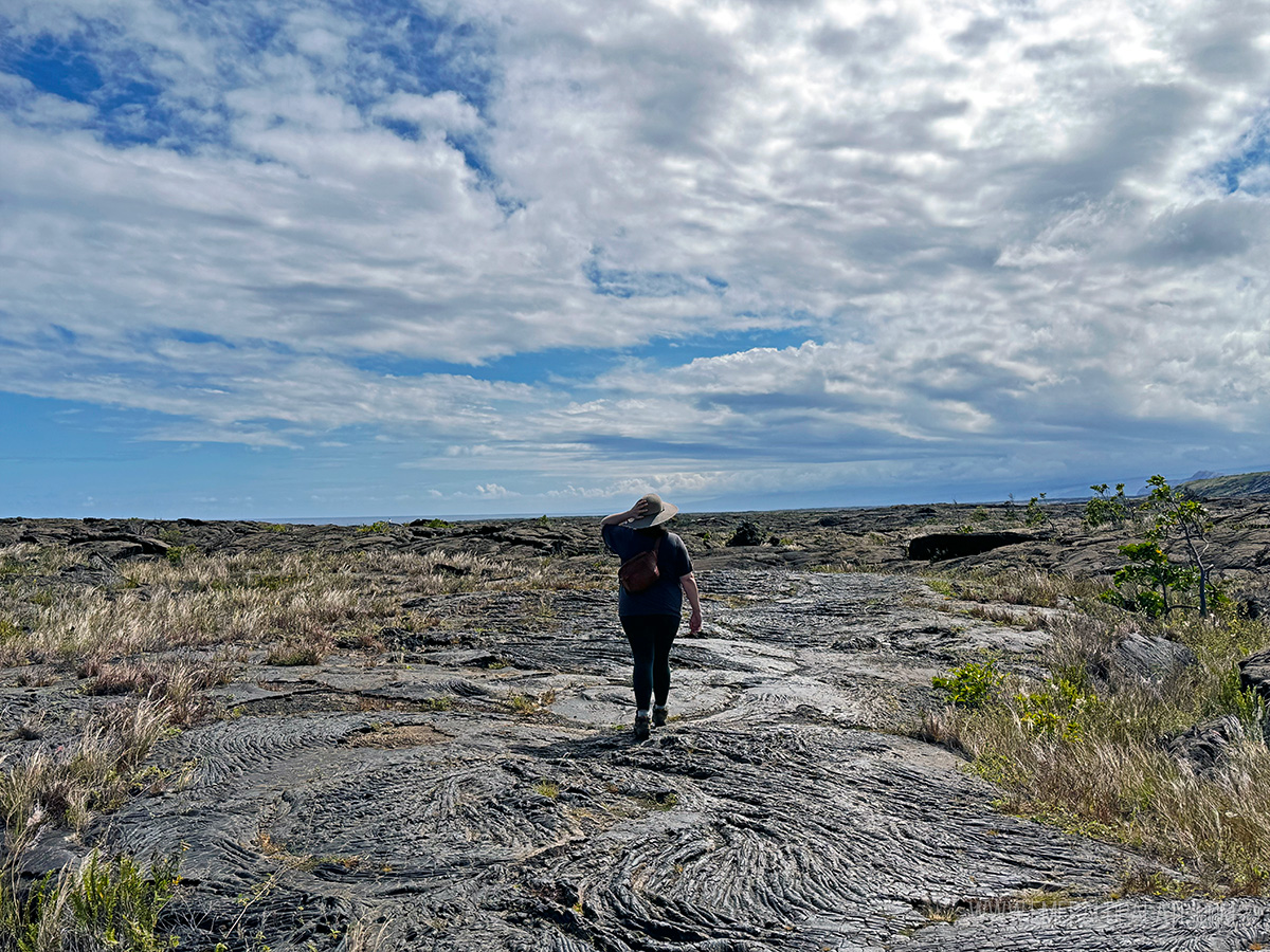 woman walking along hardened lava at Hawai'i Volcanoes National Park