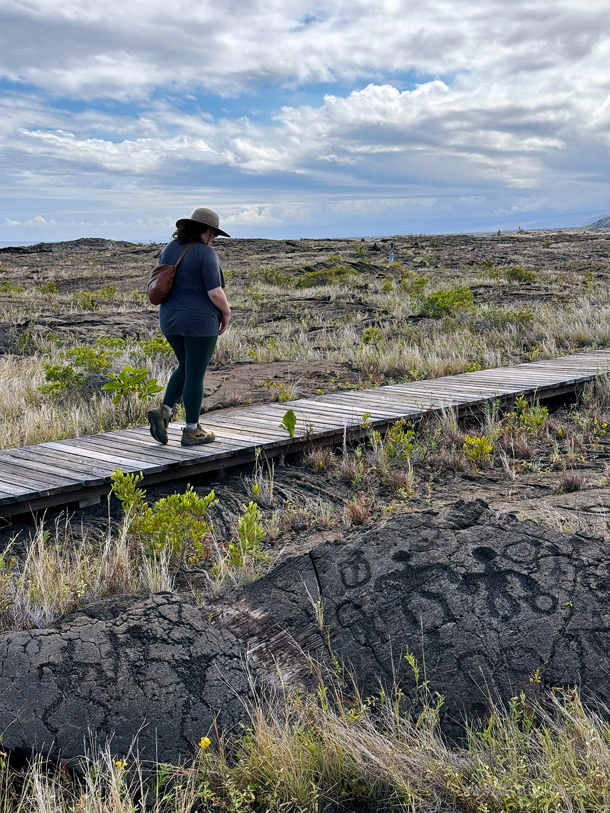person walking next to petroglyphs in Hawaii Volcanoes National Park
