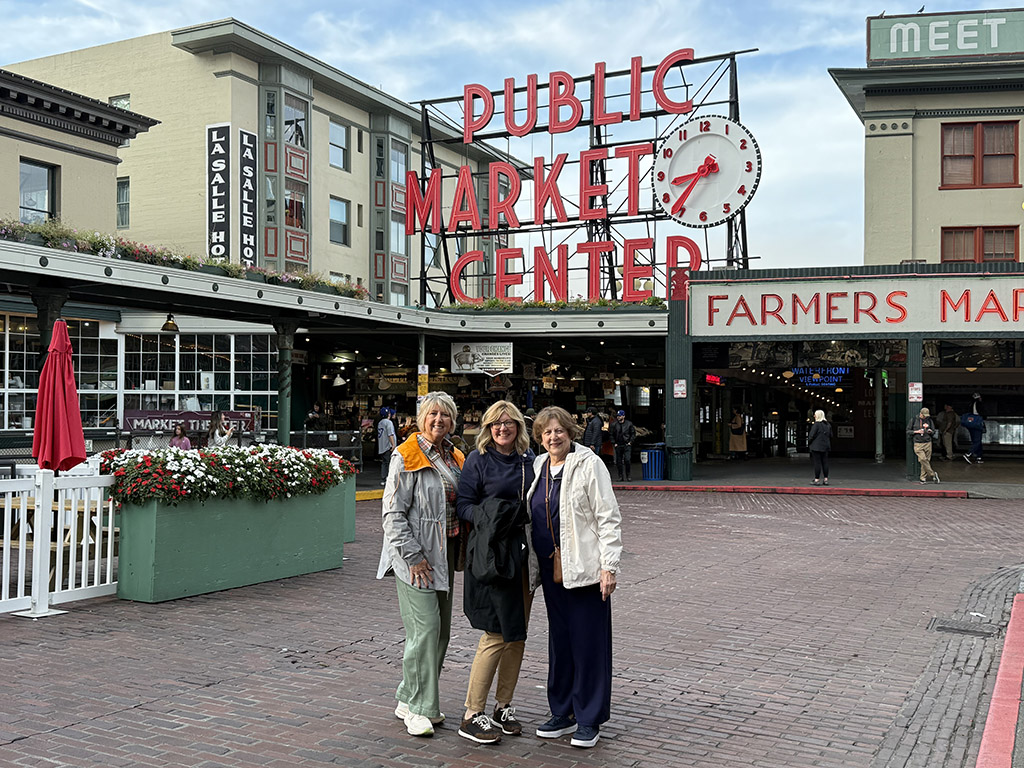 3 travel planning clients in front of Pike Place Market