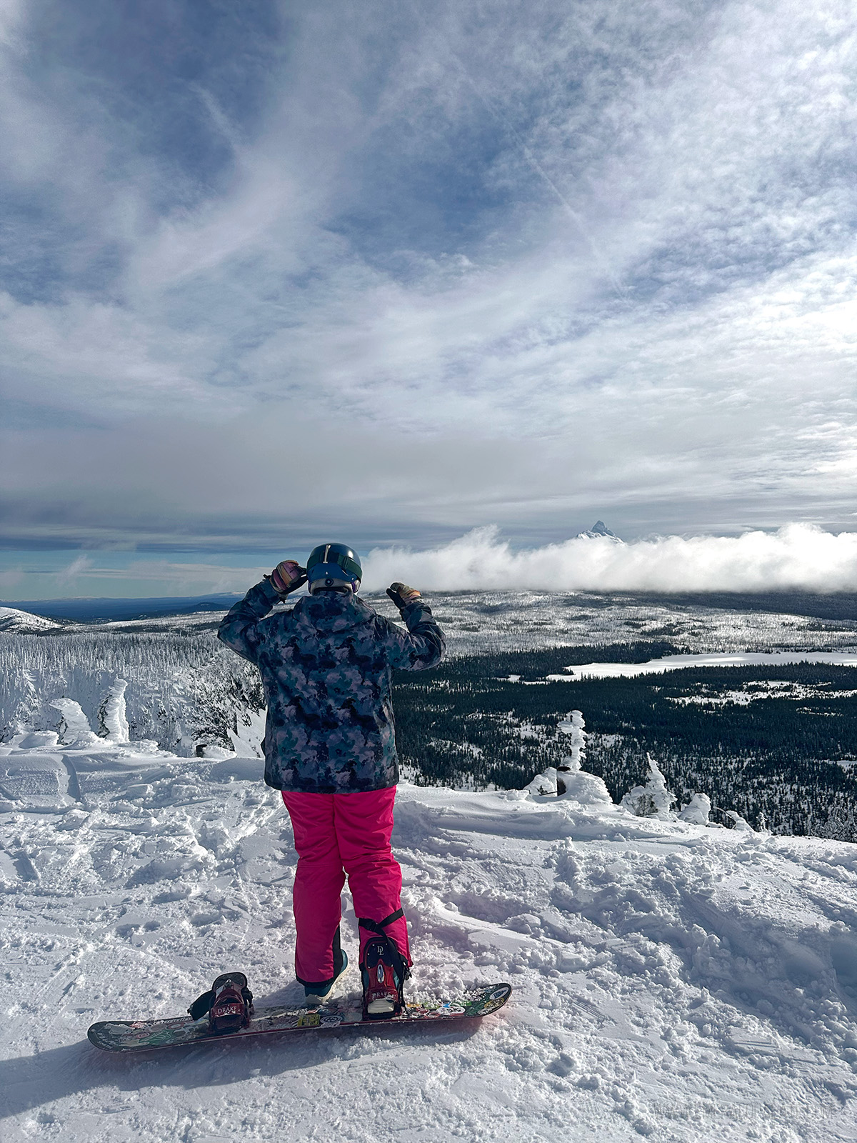 snowboarder enjoying vistas at the top of a resort while Bend, Oregon skiing