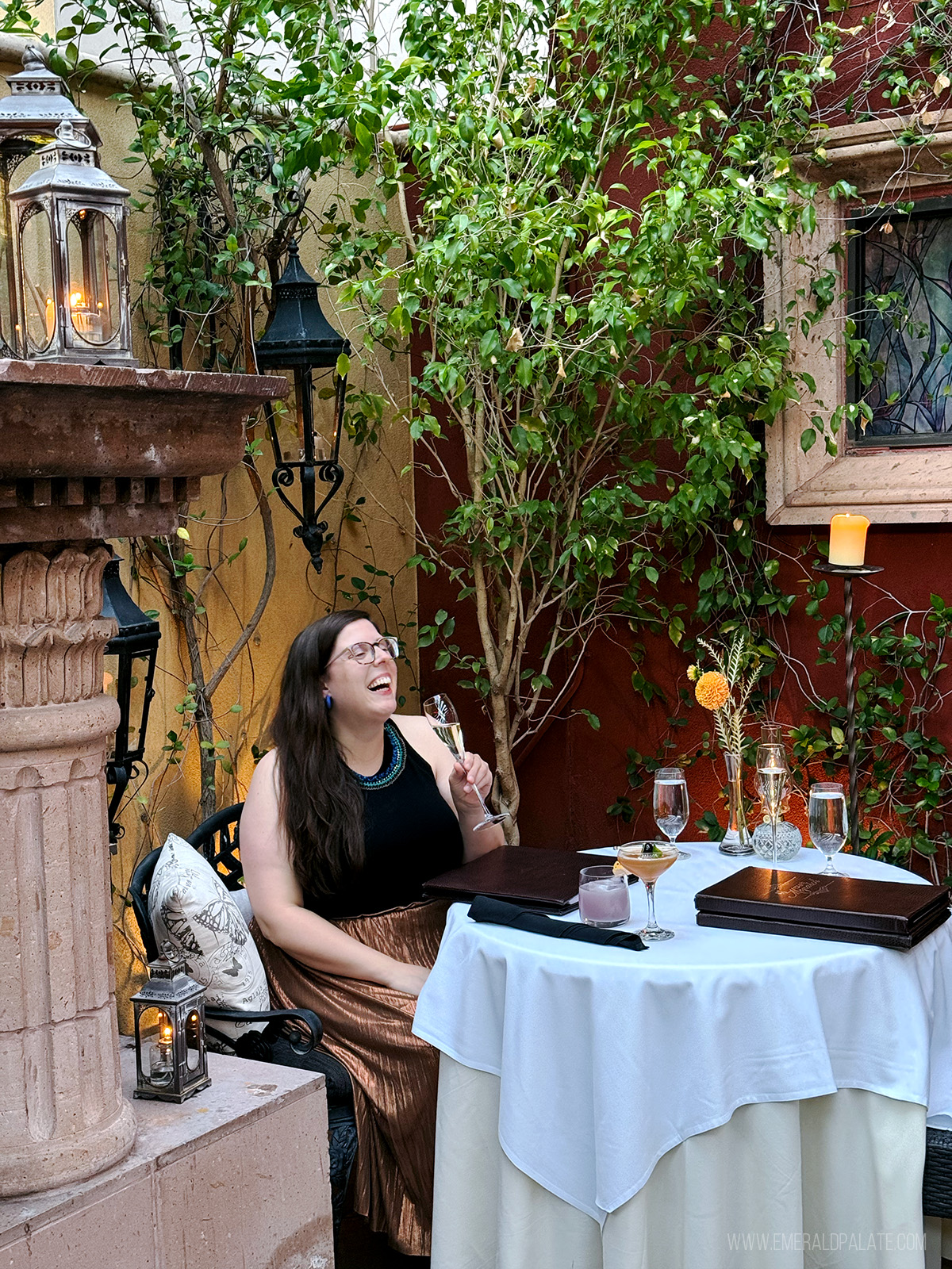 woman laughing enjoying champagne at a restaurant's outdoor patio in Scottsdale AZ