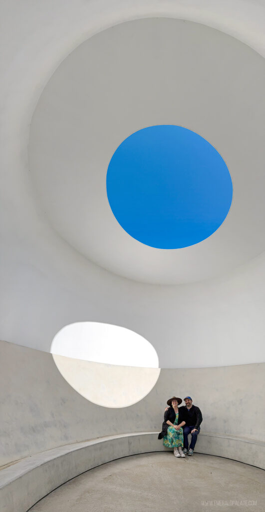 couple posing in an art structure with a huge hole in top to let in light at SMOCA, one of the best things to do in Scottsdale, Arizona