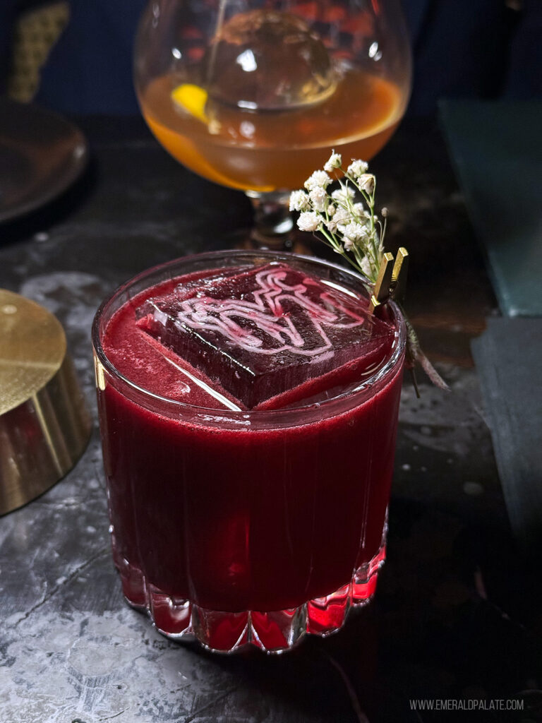fancy cocktail with ice branded with the letters TYF from a Scottsdale speakeasy bar