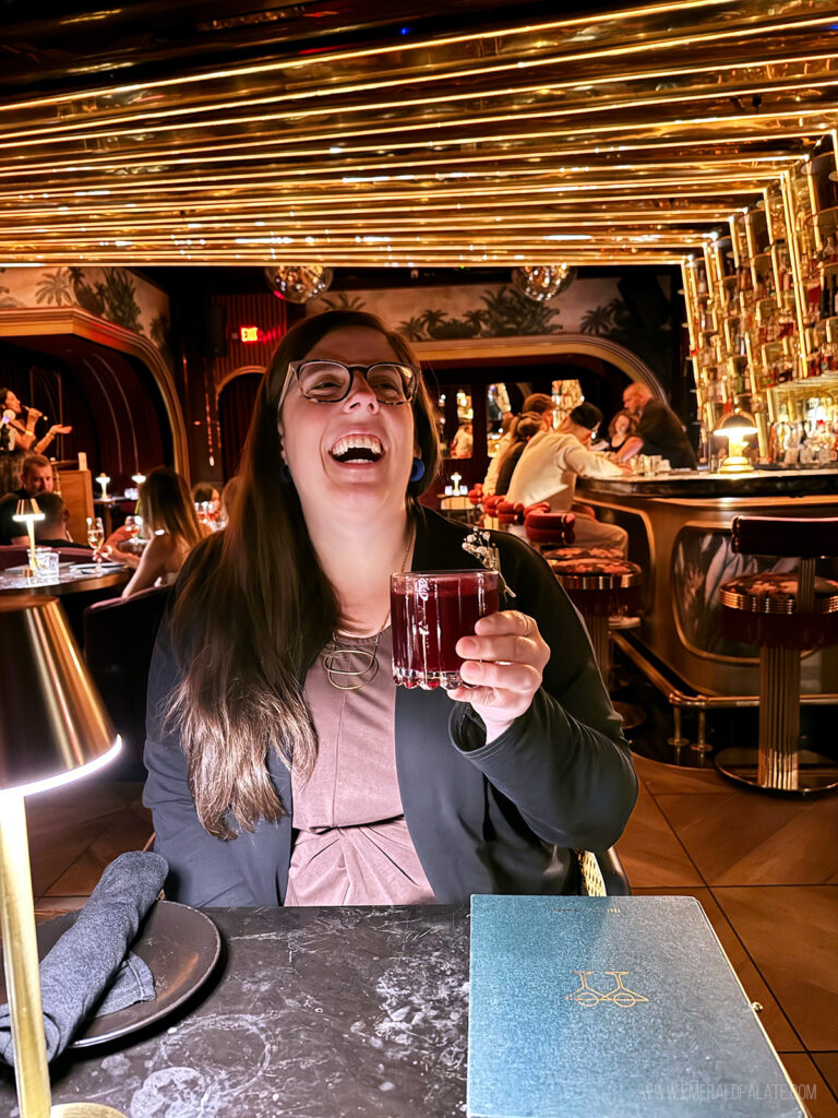 woman laughing over a cocktail at one of the best speakeasy bars in Scottsdale AZ