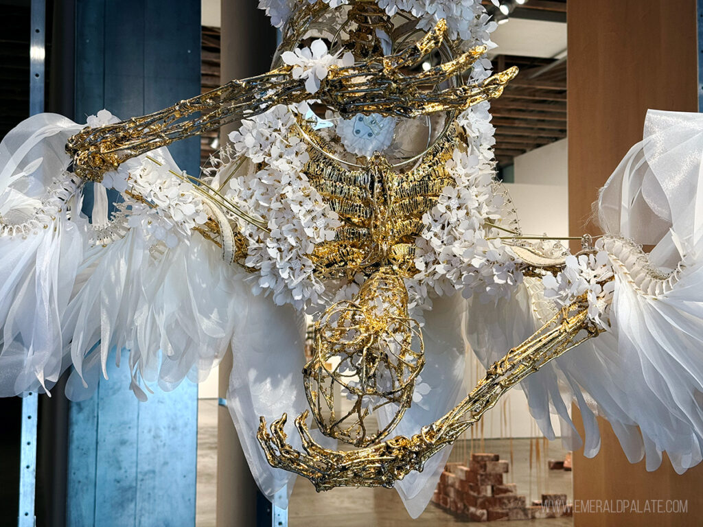beautiful modern art sculpture of a fallen skeleton angel hanging upside down in a museum, one of the best things to do in Scottsdale, Arizona