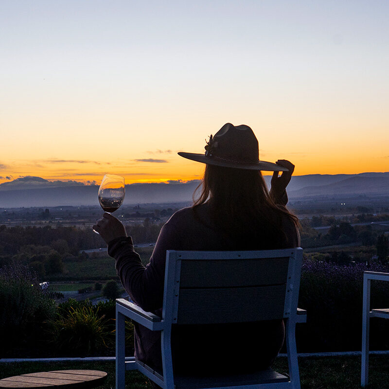 woman drinking wine while enjoying the sunset view at one of the best Yakima Valley wineries