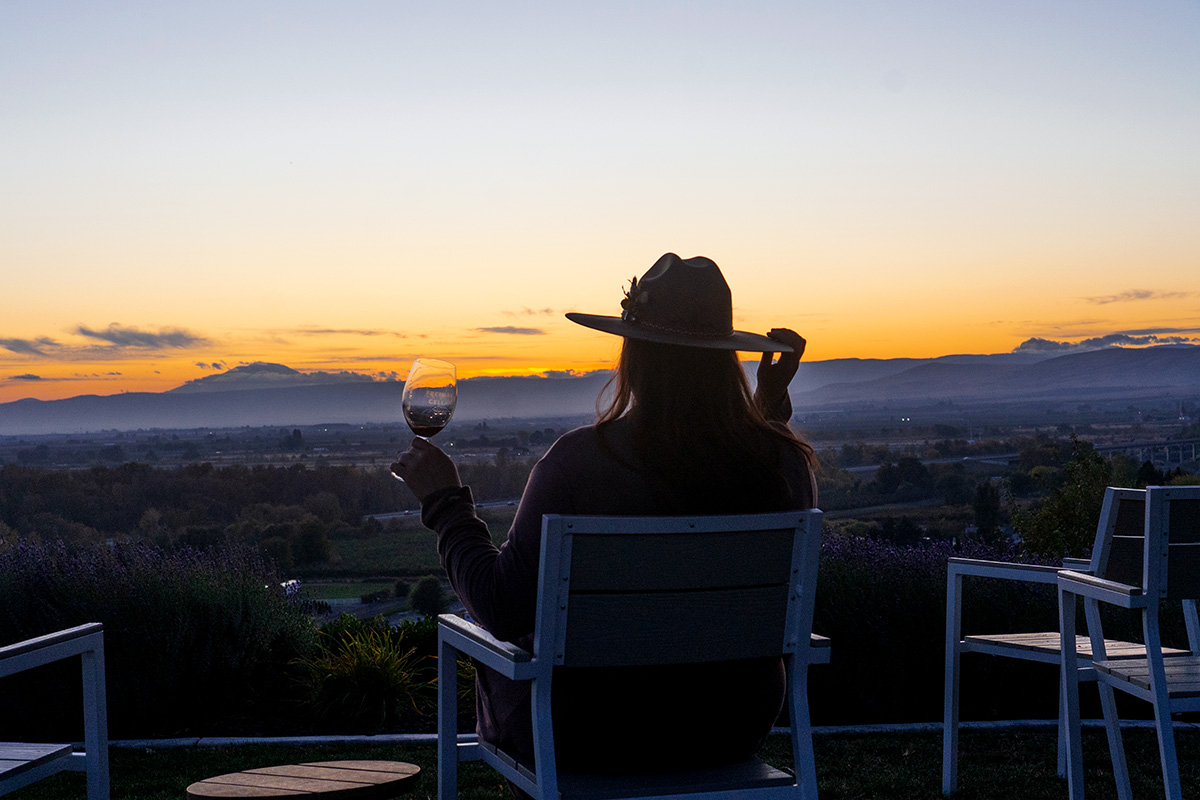 woman drinking wine while enjoying the sunset view at one of the best Yakima Valley wineries