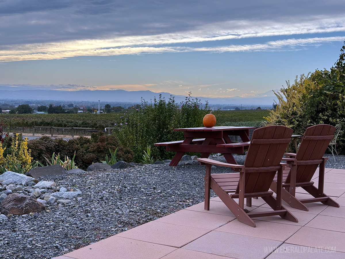 Views during sunset of an Adirondack chair on the patio of a Yakima tasting room