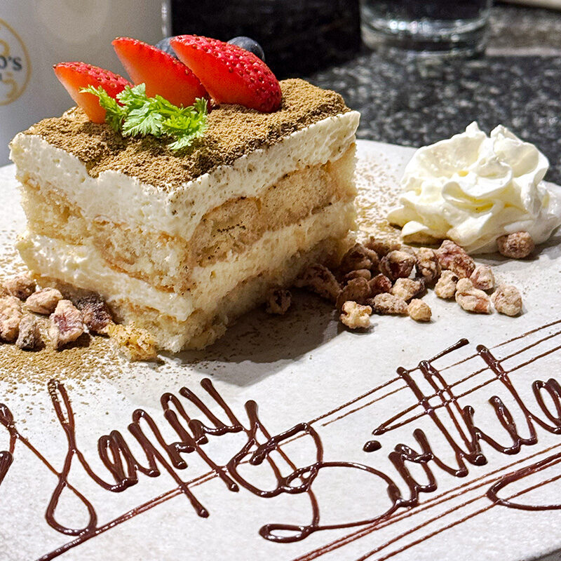 birthday cake on a plate that says Happy Birthday at one of the best restaurants for birthdays in Seattle