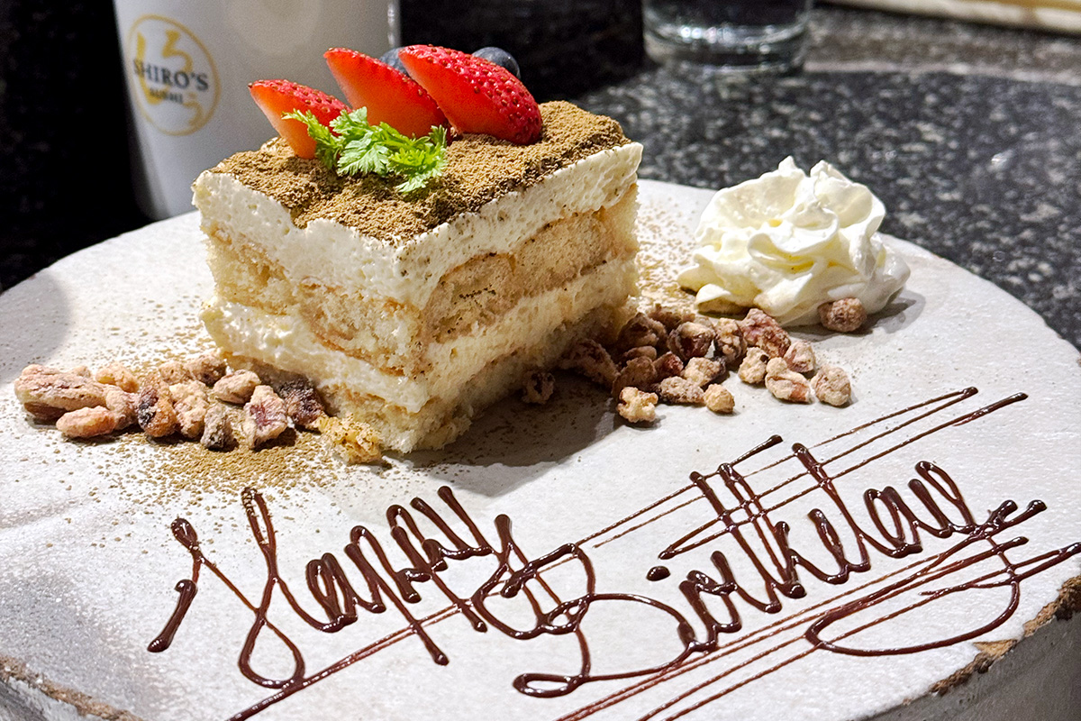 birthday cake on a plate that says Happy Birthday  at one of the best restaurants for birthdays in Seattle