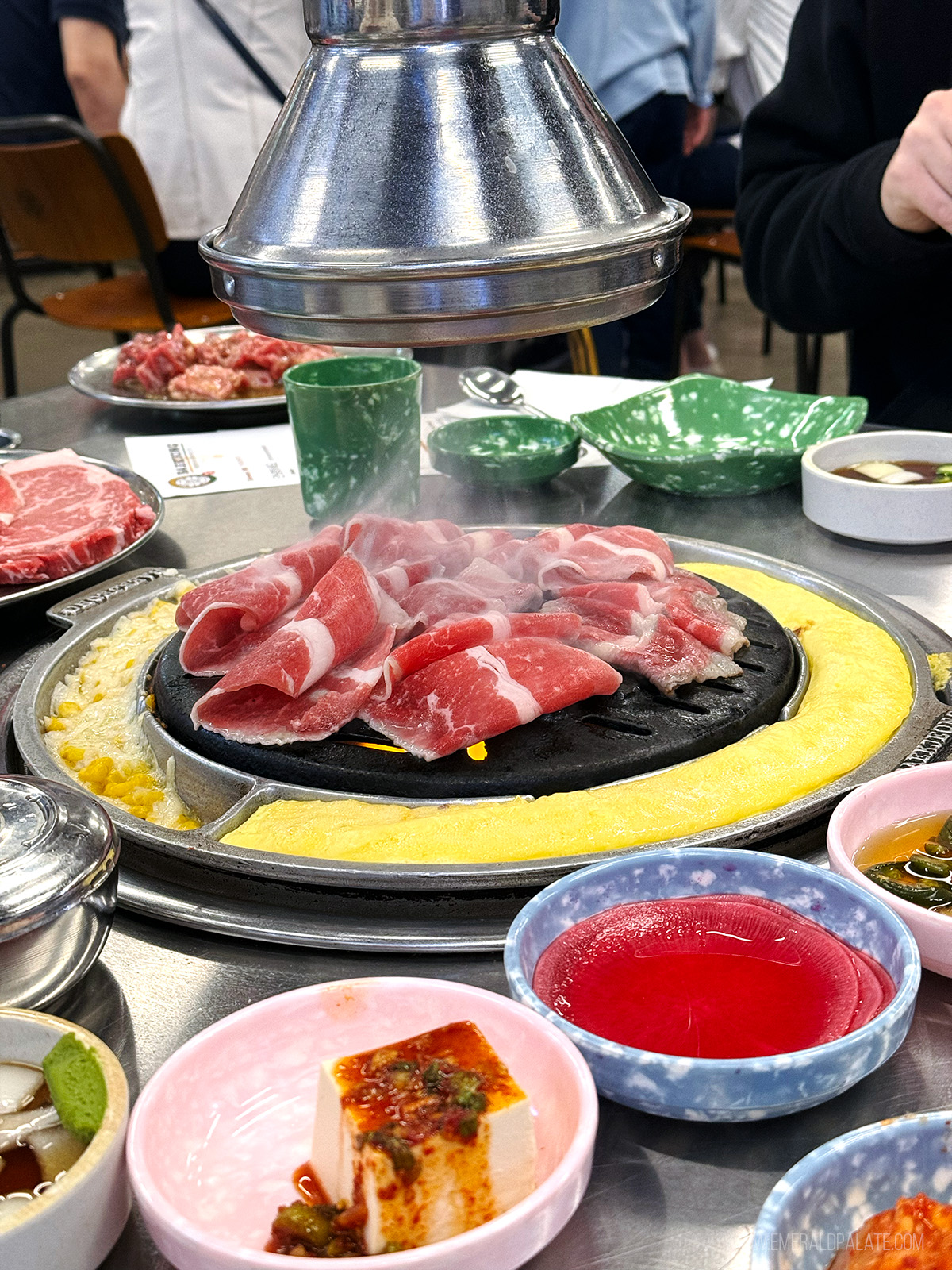 person grilling meat at a KBBQ spot in Seattle