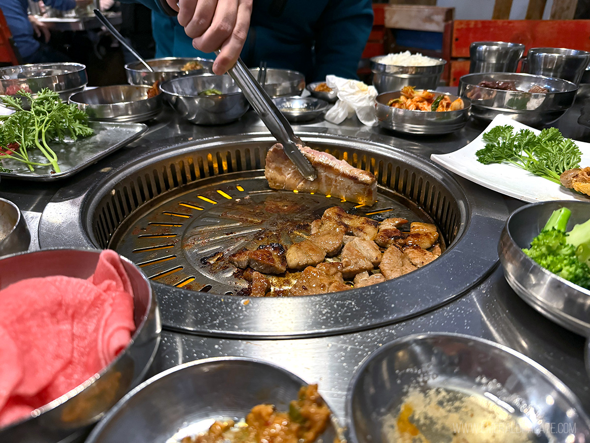 person grilling pork belly at Korean BBQ in Seattle, WA