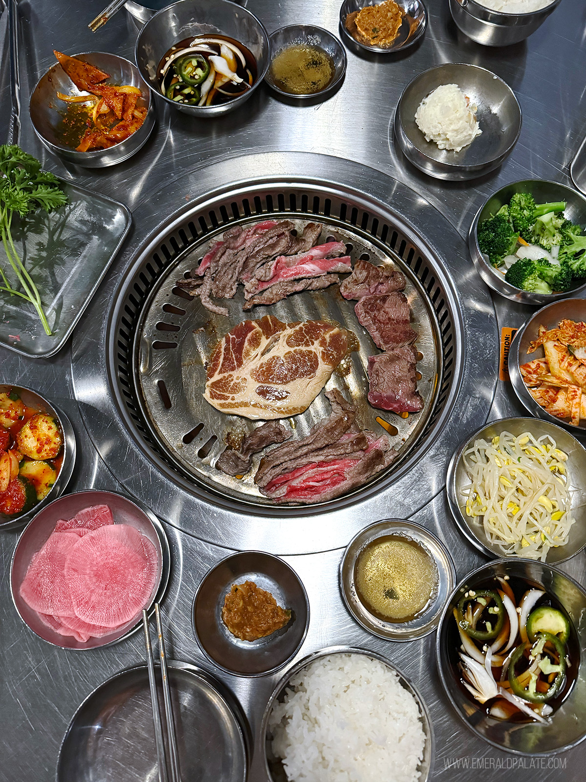 Korean BBQ table full of banchan, side dishes, and meats