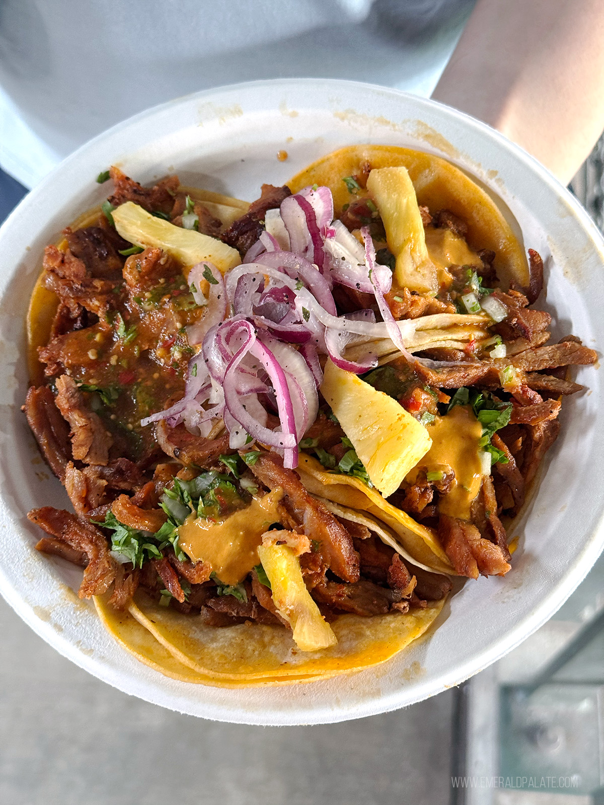 person holding plate of tacos from T Mobile Park