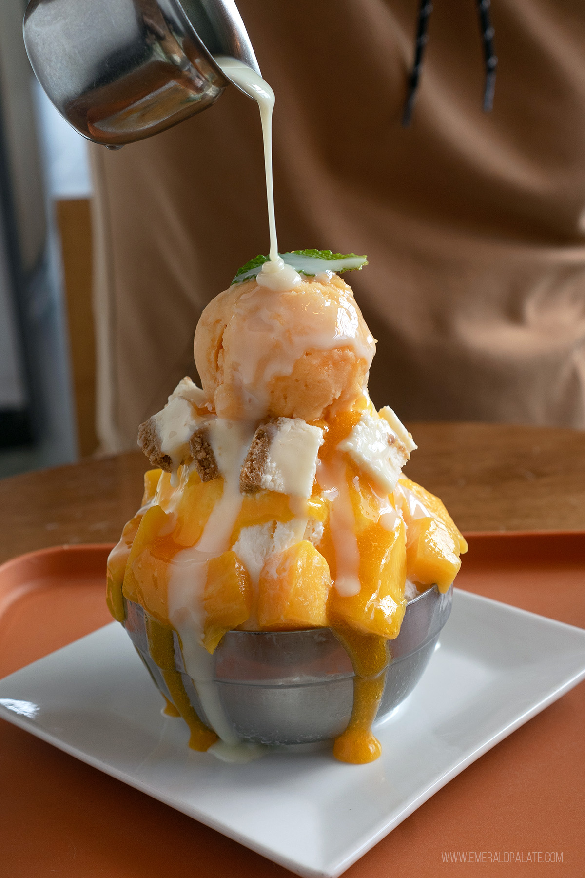 person drizzling cream over a bingsu ice cream in Lynnwoodone of the best restaurants to do in Snohomish County