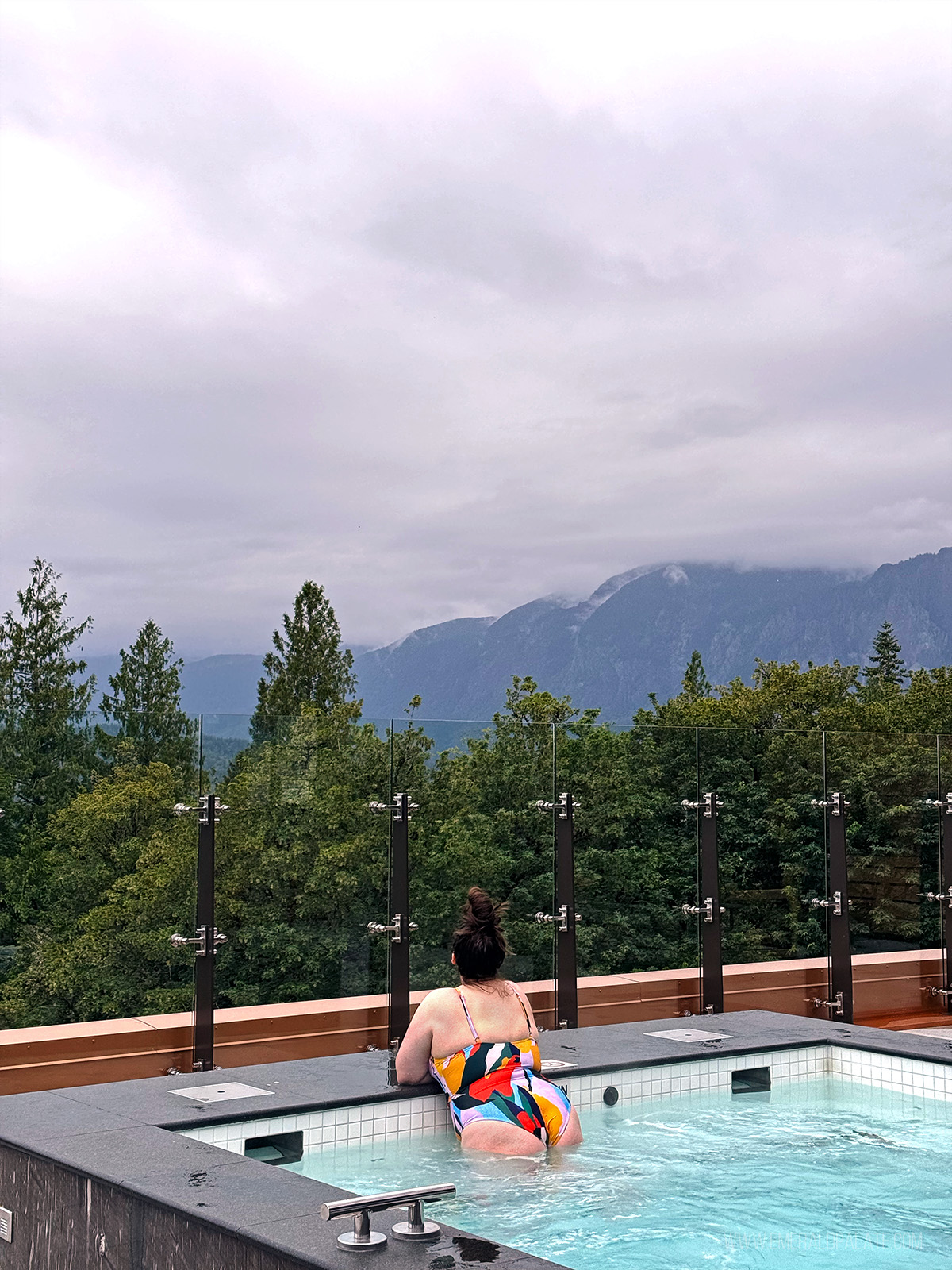 woman taking in mountain views from an outdoor hot tub at one of the best Pacific Northwest resorts